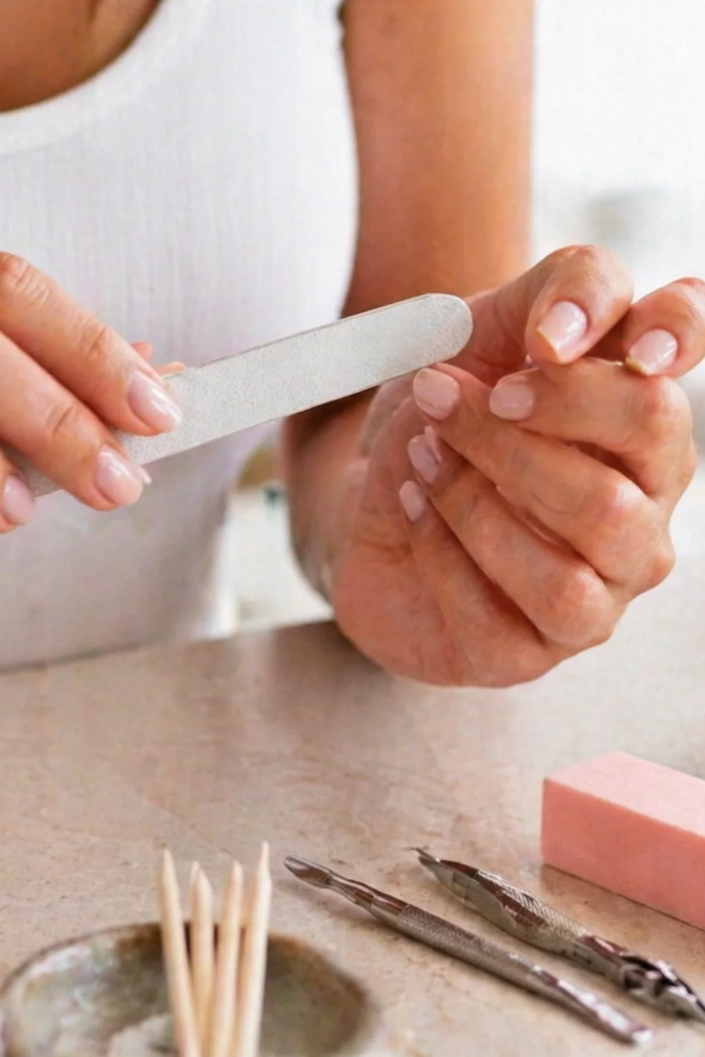 pin vertical de uñas rosas con manicura elegante